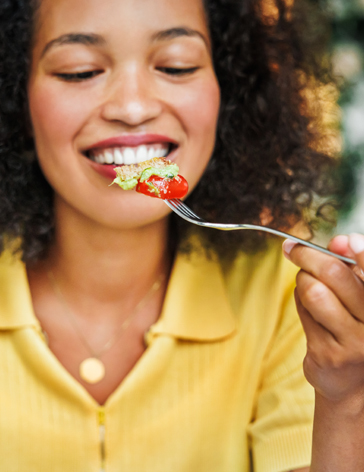 Lady eating bite of healthy food