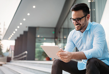 Smiling man in glasses looking at tablet