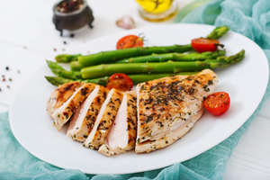 Dinner plate with grilled chicken, asparagus and tomatoes